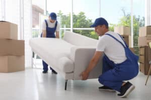 Two Movers Carrying Sofa In Room